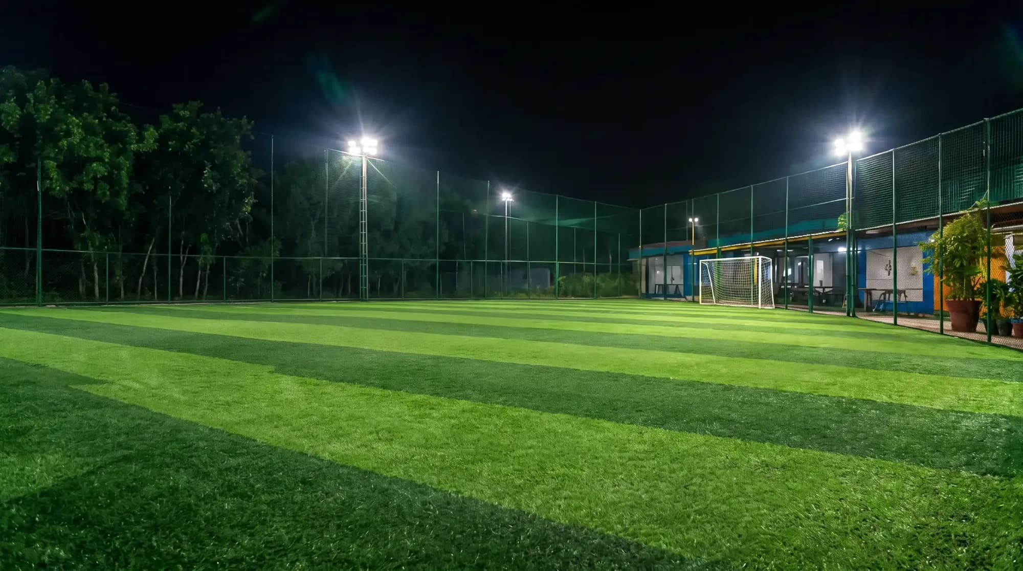 Floodlit football turf at Olipur Royal Sports Complex at night